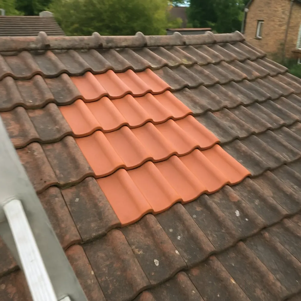 Tuiles neuves remplaçant une zone de tuiles cassées sur un toit